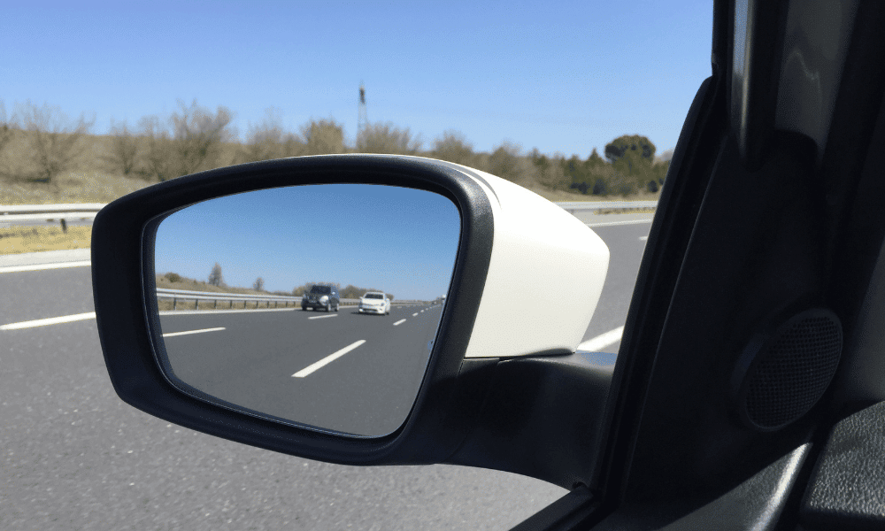Ajuste manual del espejo retrovisor en el interior del coche.