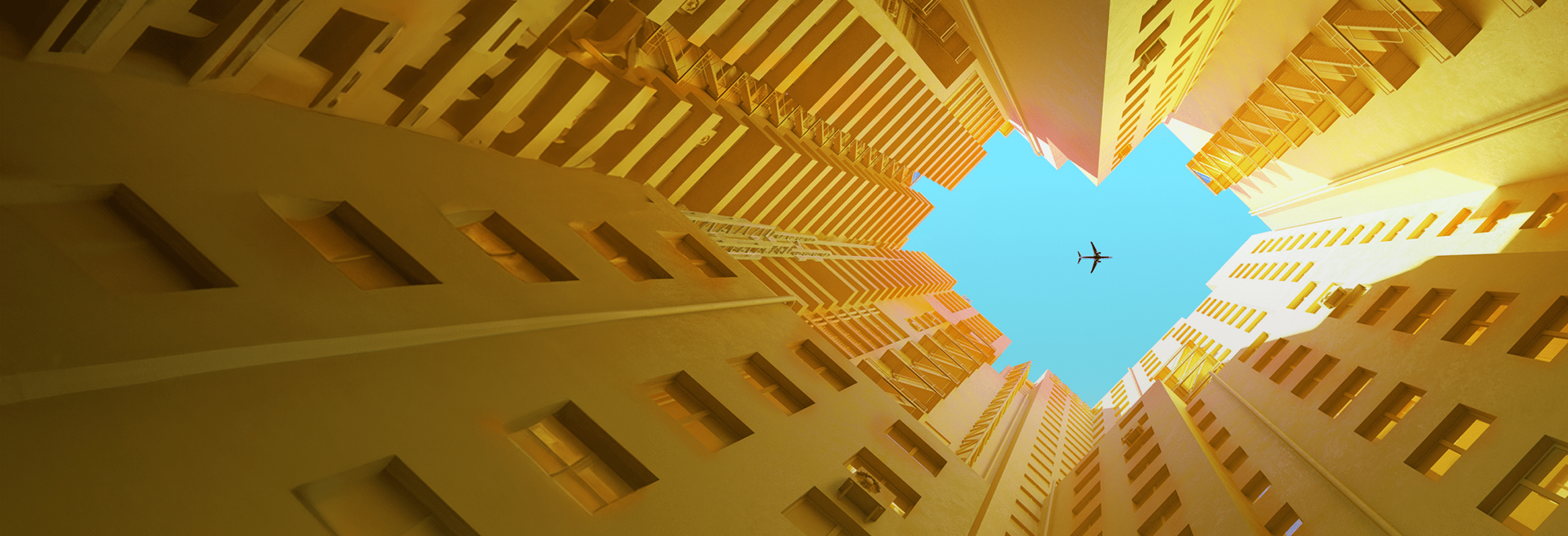 Digital generated image of orange buildings making heart shape with airplane flying on blue sky.