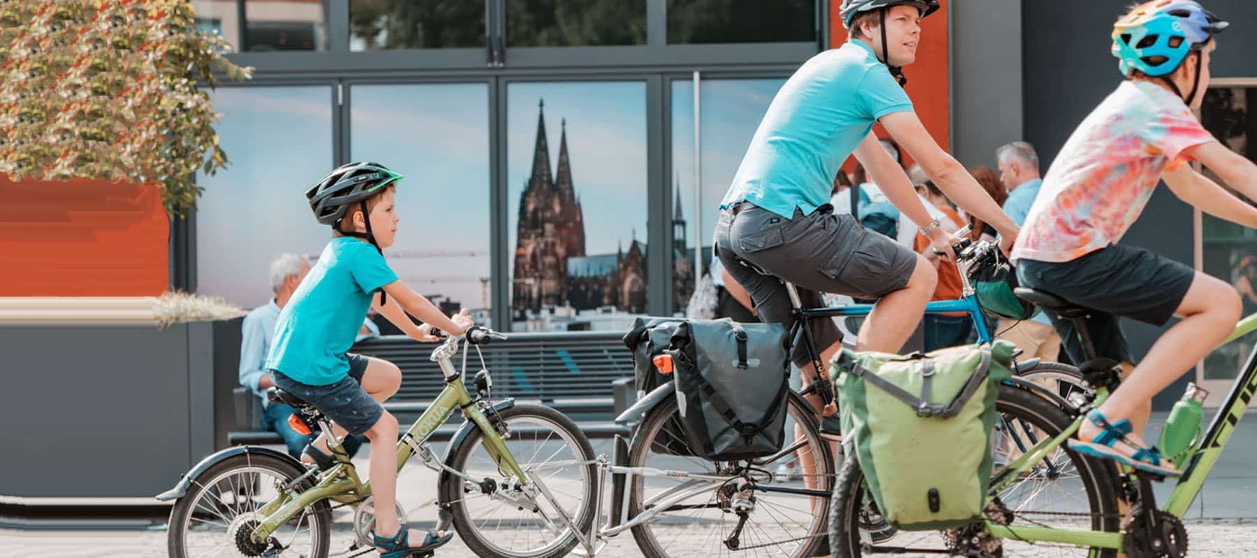 A sports family – a father with a child ride bicycles through the streets of an old European city