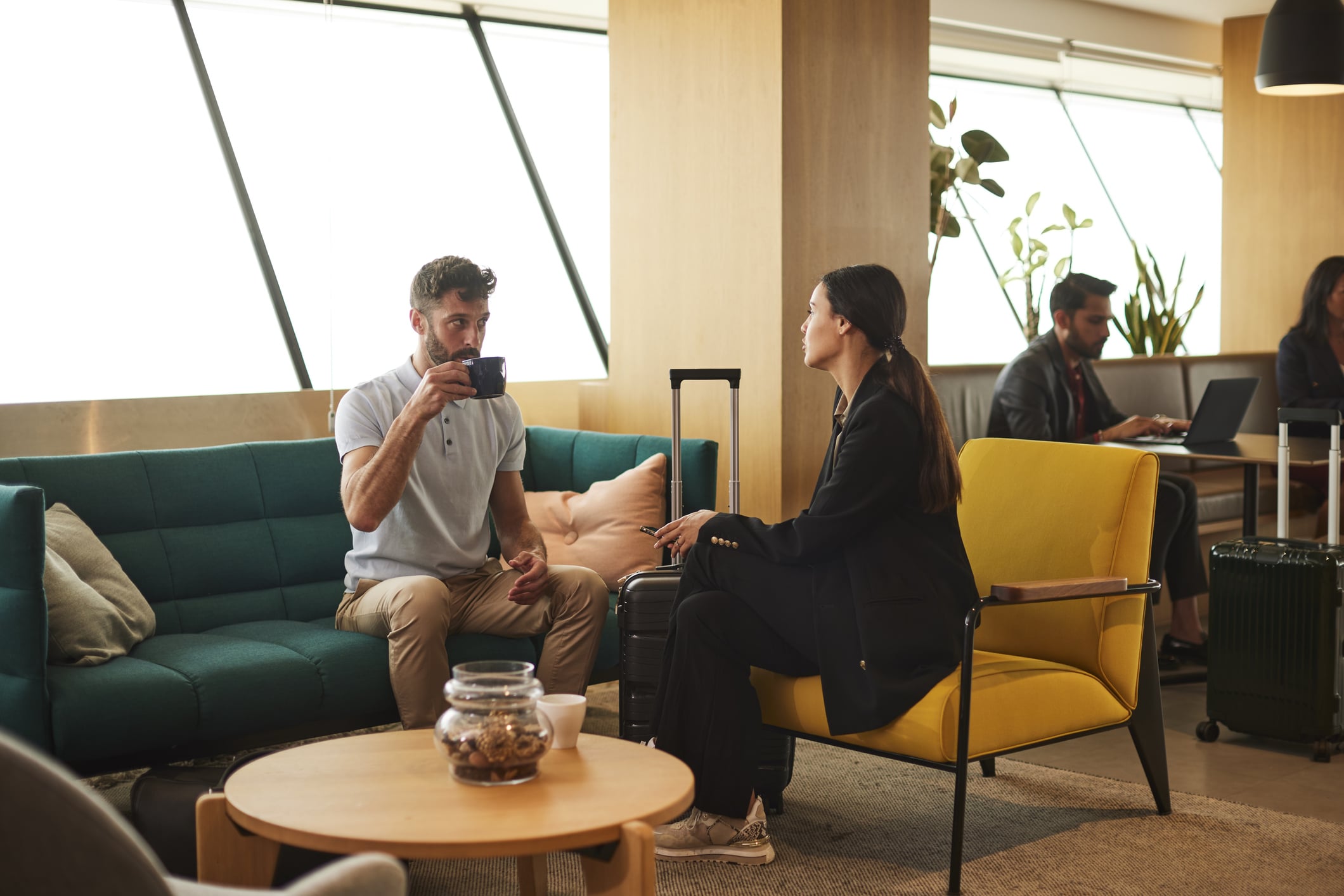 Professional Exchange: Business Travelers Discuss Matters in an airport coffee shop.